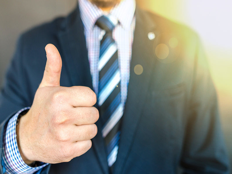 man in suit and tie with a thumbs up for new job